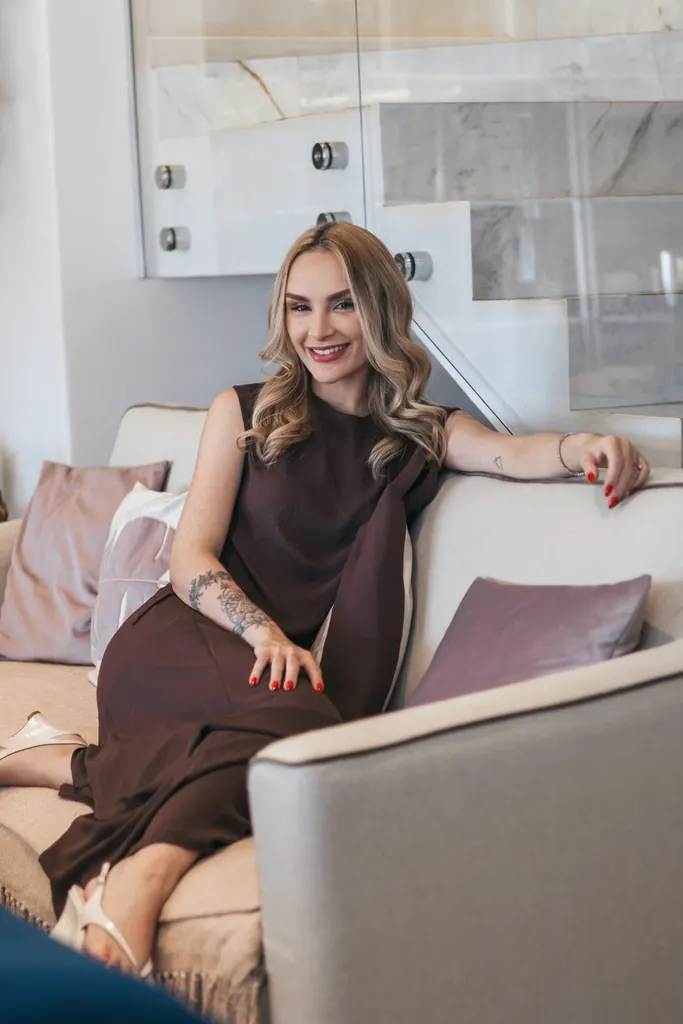 Dra. Amanda Mazetto sorrindo, sentada no sofá do consultório